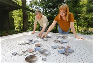 Sue Szabo and her husband David Smith use a peg board to arrange completed disks helping them visualize the final layout, at their Sylvania Township home.