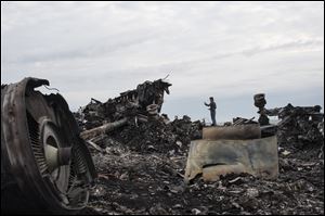 A journalist, background, takes a photo at the crash site of a Malaysia Airlines jet today near the village of Hrabove, eastern Ukraine.