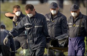 Emergency workers carry the body of a victim at the crash site of Malaysia Airlines Flight 17.
