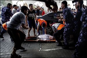 Palestinian medics carry a wounded woman to an emergency room at Shifa hospital Sunday in Gaza City.