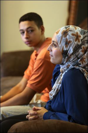 Tariq Abu Khdeir, 15, left, sits with his mother Suha Khdeir during interview in their home Sunday in Tampa.