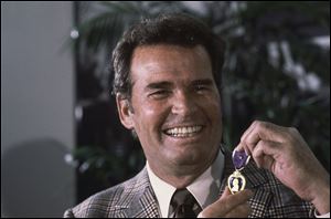 Actor James Garner, left, smiles as he holds up the Purple Heart medal presented to him in a ceremony in this Monday, Jan. 24, 1983 file photo taken Los Angeles, Calif. Garner was wounded in April 1951 while with U.S. Forces in Korea, but his medal was never presented to him. 