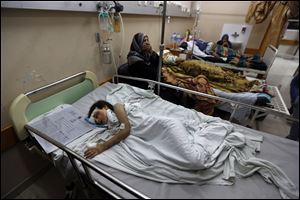 Palestinian Beisan Dhahir, 7, sleeps at Shifa hospital late Sunday in Gaza City.
