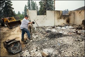John Johnson returns to clear out and salvage remnants of his burned down homeafter the Carlton Complex fire burned Sunday through the valley, near Malott, Wash.