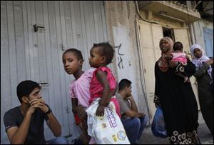 Members of a Palestinian family flee their houses in Gaza City, today.