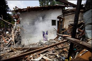 A destroyed house that was hit by a rocket fired by Palestinians militants from Gaza, in Yahud, central Israel, today. Israel has said its campaign, launched July 8, is aimed at stopping Hamas rocket fire into Israel — some 2,000 rockets have been launched over the past two weeks, the military says — and destroying tunnels the military says Hamas has constructed from Gaza into Israel for attacks against Israelis. 