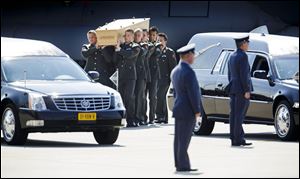 Pallbearers carry a coffin towards a hearse during a ceremony to mark the return of the first bodies, of passengers and crew killed in the downing of Malaysia Airlines Flight 17, from Ukraine at Eindhoven military air base, Netherlands, today.