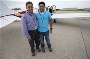 Babar Suleman and son Haris Suleman, 17, stand next to their plane at an airport in Greenwood, Ind. on June 19 before taking off for an around-the-world flight.