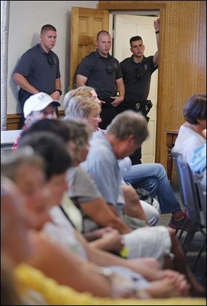 Put-in-Bay police officers listen during the meeting.