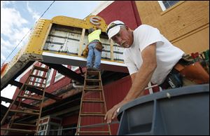 William Busch, left, and Gary Cross, right, work on restoring the marquee.