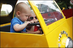 Parker Angerosa, left, 11 months, explores the interior of a 1957 Cyclops with his sister Hayden Angerosa, right, 2.