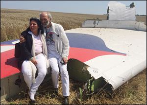 Australian couple Jerzy Dyczynski and Angela Rudhart-Dyczynski whose daughter, 25-year-old Fatima, was a passenger on Malaysia Airlines flight MH17, sit on part of the wreckage of the crashed aircraft Saturday in Hrabove, Ukraine.