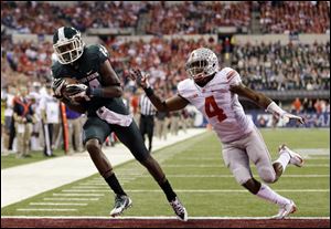 Michigan State's Tony Lippett, left, makes a 33-yard touchdown reception against Ohio State's C.J. Barnett (4) during the first half of the 2013 Big Ten Conference championship game in Indianapolis.