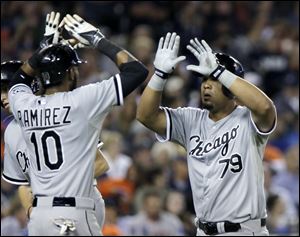 Chicago White Sox's Jose Abreu is congratulated by Alexei Ramirez after hitting a two run home run off of Detroit Tigers pitcher Joakim Soria during the seventh inning.