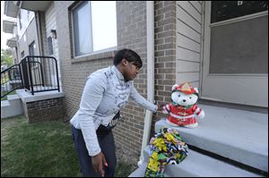 Beatrice Spears leaves a stuffed animal on the front porch of a home where an 8-year-old boy was shot and killed early today.