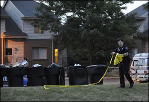 A Detroit police officer takes down the crime scene tape at the scene of a home where an 8-year-old boy was shot and killed by a bullet fired from outside that pierced the wall of his home, hitting the child in bed.