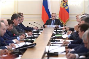 Russian President Vladimir Putin, background center, heads the Cabinet meeting in the Novo-Ogaryovo residence, outside Moscow, Russia, today. The meeting focused on measures to encourage Russian companies to pull their assets back from offshore.