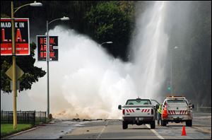 Water shoots in the air from a broken 30-inch water main under Sunset Boulevard, uphill from UCLA in the Westwood section of Los Angeles, Tuesday.