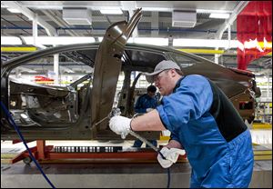 An assembly line employee works on a 2015 Chrysler 200 at the Sterling Heights Assembly Plant in Sterling Heights, Mich. The rough winter weather might have contributed to a big increase in spring automobile sales, one economist said, as weather-damaged cars were replaced or repaired.