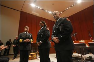 Toledo Fire Department Chief Luis Santiago stands with Lolita Cooper, left, and  Joseph Mazur, right, after the were promoted from private to lieutenant with the Toledo Fire & Rescue in City Council Chambers today.