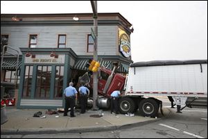 Toledo police examine a tractor-trailer rig after it crashed into Tony Packo's restaurant on Front Street in East Toledo.