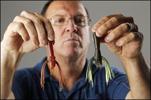 Greg Dorris holds two of his patented bass baits, called Whiskers.