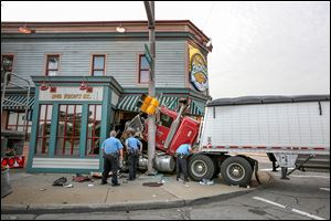 Toledo police examine a tractor-trailer after it crashed into the Tony Packo’s restaurant.