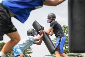 Perrysburg running back/linebacker Chase Banks, left, works on a drill with wide receiver Jake Myers during Friday’s practice.