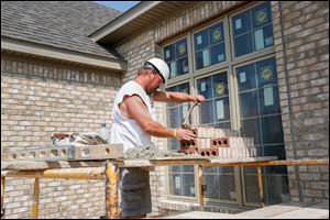 Mason Kenneth Collignon works on the Pinafore Lane home in the Blystone Valley subdivision in Maumee.  Many experts, though puzzled that housing is not leading the economic recovery, agree that the improvements have been solid.