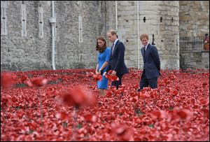Britain's Prince William, the Duke of Cambridge, center, walks with Kate, the Duchess of Cambridge and Prince Harry, right,  as they view the Tower of London's 'Blood Swept Lands and Seas of Red' poppy installation, to commemorate the 100th anniversary of the outbreak of World War I.