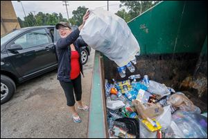  Jessica Calevro recycles a large bag of water bottles at the recycling area behind Kroger on 7545 Sylvania Ave. near King Road.