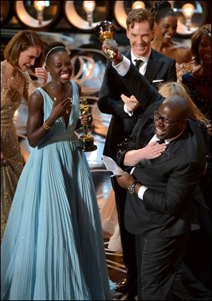 Actress Lupita Nyong'o, left, and director Steve McQueen celebrate onstage as they accept the award for best picture of the year for ‘‍12 Years a Slave’ during the 2013 Oscars.