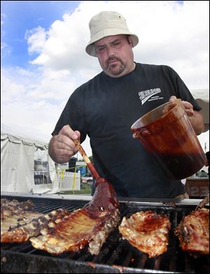Eric Sitter, co-owner of Sidelines Sports Eatery and Pub, coats his ribs with sauce at a past rib-off.