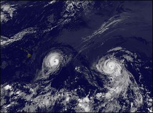 Hurricane Iselle, left and Hurricane Julio, right, near Hawaii, far left.