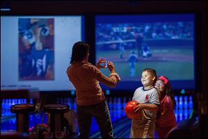 Jacqueline Martinez takes a picture of her son Ryan, 6, and daughter Isabel, 4, at Lucky Strike in Chicago. The number of U.S. bowling alleys has fallen fron 10,000 in the early 1980s to about 4,500. 