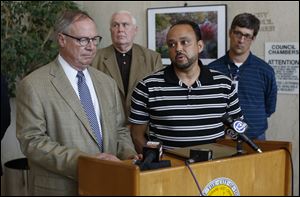 Toledo Mayor D. Michael Collins, left, and Ed Moore Toledo director of public utilities, talk during a news conference today at One Government Center. Behind them are Bob Reinbolt, the mayor's chief of staff, and Andy McClure superintendent of the Collins Park water treatment plant.
