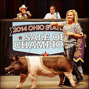 Hannah Frobose shows off her crossbred hog, Moby, while auctioneers look on during the 2014 Ohio State Fair.