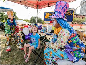 Nevaeh Cooper, 4, of Northwood, center, thanks Happy the Clown (Matthew Onweller of Swanton), right, for her balloon princess as Laffy the Clown (Chase Tressler of Swanton) watches.