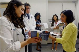Dr. Emily Krennerich, left, and Tina Navidi refer to 'The Harriet Lane Handbook' as they make the rounds with medical students. Each doctor wrote a chapter in the 20th edition of the book.