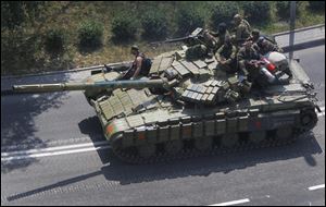Pro-Russia rebels on a tank drive Sunday on a road in Donetsk, eastern Ukraine. Fighting raged Sunday in the eastern Ukrainian city of Donetsk despite a request from the pro-Russian rebels there for a cease-fire to prevent a 