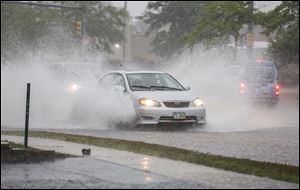 Cars fight their way through high water on Talmage Road between Monroe Street and Sylvania Avenue.