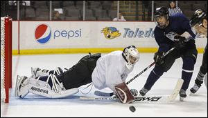 Goaltender Jordan Crudo of Tulsa, Okla., blocks a shot of Garrett Torres by Chicago at the Walleye’s free-agent camp as 80 players showed their skills at Huntington Center. Prospect paid $275 for a chance to impress the team.