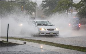 Cars splash their way on Talmage Road on Monday. Serious rainfall ended a run of dry weather, forcing many area roads to close, swamping houses, and prompting tornado worries. In some spots in Perrysburg, 5 to 6 inches of rain had fallen by 2 p.m., according to the National Weather Service. 