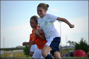 Maya Kinney, in white, playing soccer for the Greater Toledo Futbol Club. She is 13 and having major surgery this winter to straighten out her spine from a severe case of adolescent scoliosis. There is a fundraiser Saturday to help out the family with costs.