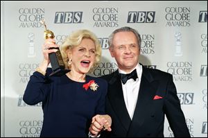 Lauren Bacall holding up her Cecil B. DeMille Award for Lifetime Achievement as she holds hands with actor Anthony Hopkins backstage at the 50th annual Golden Globe Awards in Beverly Hills, Calif on Jan. 23, 1993.