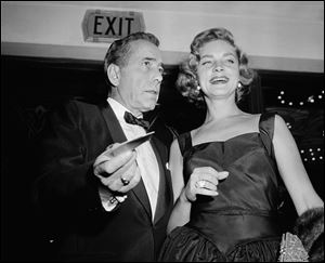 This Oct. 12, 1955 file photo shows actors Humphrey Bogart, left, and his wife, Lauren Bacall at the premiere of 
