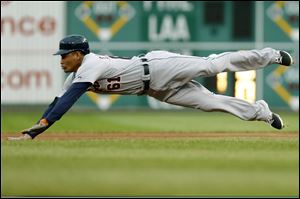 Detroit Tigers' Ezequiel Carrera (61) dives for second base with a double in the first inning.