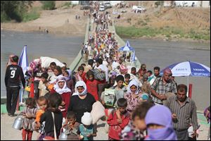 Displaced Iraqis from the Yazidi community cross the Syrian-Iraqi border along the Fishkhabur bridge over the Tigris River at the Fishkhabur crossing, in northern Iraq.