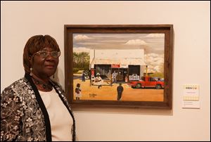 Willie N. Shahraki-Heard poses with her oil painting, ‘‍The Old General Store.’ It’s at Myles Baker Street, a cafe at 434 E. Wooster St., Bowling Green. The painting won Best of Show at this summer’s Northwest Ohio Community Art Exhibition.