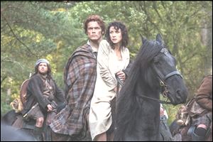 Caitriona Balfe as Claire Randall, right, and Sam Heughan as Jamie Fraser, and Grant O'Rourke as Rupert MacKenzie, in a scene from Starz' new TV series, 